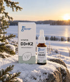 D3+K2-pakkaus ja tippapullo lumisella kalliolla talvisen järven rannalla