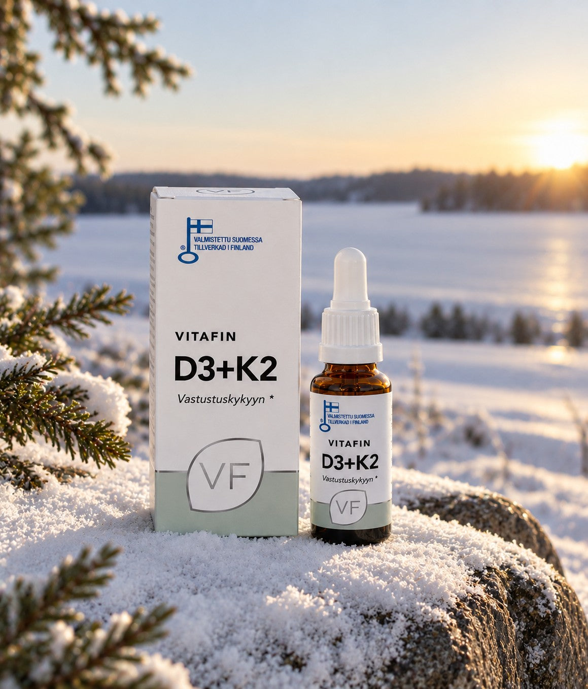 D3+K2-pakkaus ja tippapullo lumisella kalliolla talvisen järven rannalla